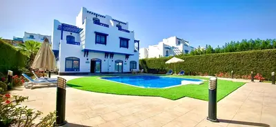 a villa with a swimming pool in front of a building at Luxury 8BR Villa with seaview and private pool in Hurghada in Hurghada