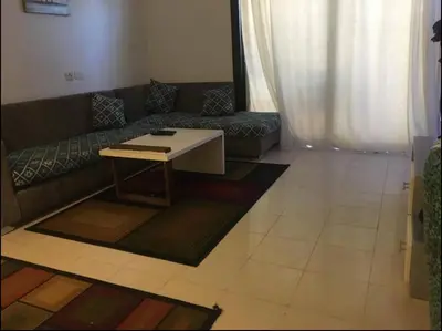 a living room with a couch and a table at Pool view one bedroom - B203 in Hurghada