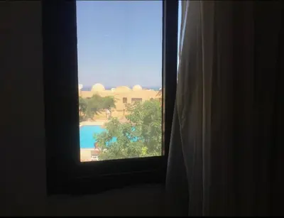 a window in a room with a view of a pool at Pool view one bedroom - B203 in Hurghada