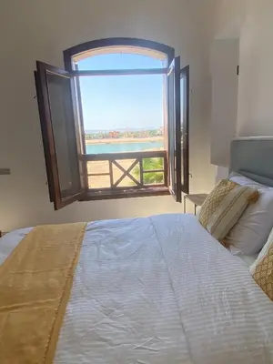 a bedroom with a large bed and a large window at Sabina 2br penthouse in Hurghada