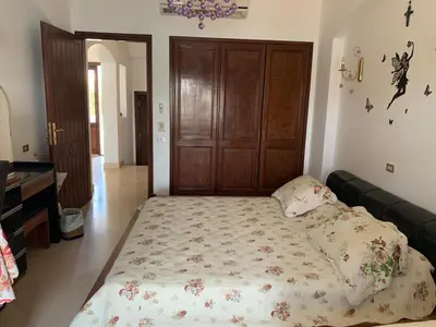 a large bed in a room with a wooden door at 3Bedrooms Villa with Private Pool and direct Lagoon Access in Hurghada