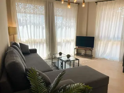 a living room with a couch and a tv at Lovely 1 Bedroom apt. At Mangroovy residence with free access to the Beach and Pools in Hurghada