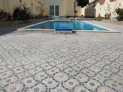 a pool with a tiled floor next to a building at Jasmine villa in Hurghada