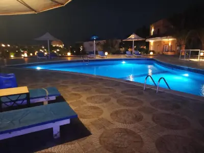 a swimming pool at night with a slide in it at Dolphin Continental Hotel in Quseir