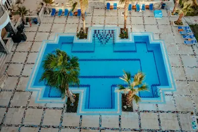 an overhead view of a swimming pool with palm trees at Royal Star Beach Resort in Hurghada