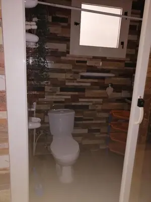 a bathroom with a toilet and a stone wall at Apartment near the sea in Hurghada