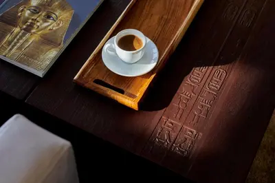 a cup of coffee on a tray with a book at Mövenpick Royal Lily Nile Cruise, Every Monday Four Nights From Luxor, Every Friday Three Nights From Aswan - Including Excursions & Sightseeing in Luxor