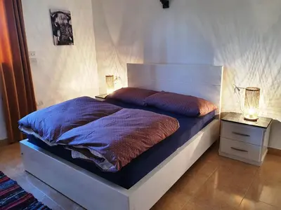 a bedroom with a bed and a lamp on a night stand at CASA LOKO Guest House in Luxor