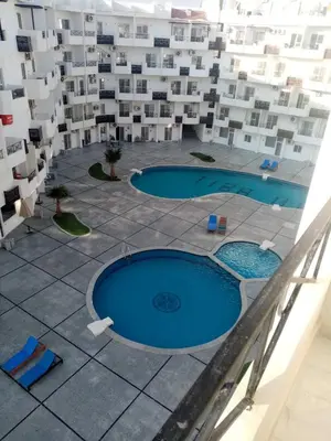 an aerial view of two swimming pools in a building at Studio in compaund in Hurghada