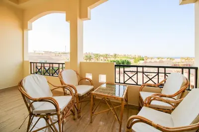 a room with chairs and a table on a balcony at Sahl Hasheesh, El Andalous by All View apartements in Hurghada