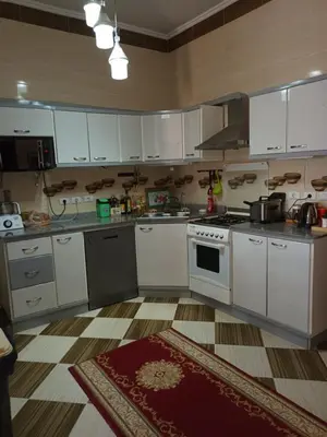 a kitchen with white cabinets and a stove at Rum i villa med pool in Hurghada