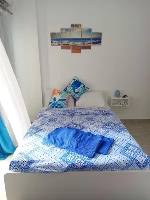 a bed with blue sheets and pillows in a bedroom at Aqua Palms resort -Lovely studio in Hurghada