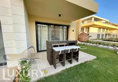 a patio of a house with a bench in the grass at G-Cribs 2 Bed Rooms in Hurghada