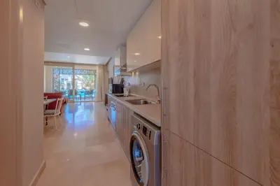 a kitchen with a washer and dryer and a sink at Elegant 2-Bedroom Apartment in Mangroovy, Pool & Beach in Hurghada