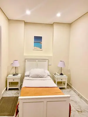 a bedroom with a bed and two lamps on tables at Tiba Rose hurghada in Hurghada