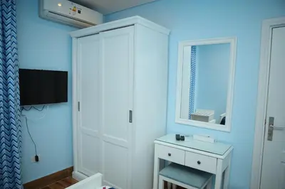 a blue room with a white cabinet and a tv at Tiba Rose hurghada in Hurghada