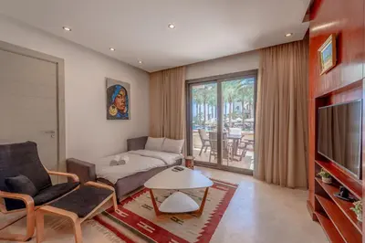a living room with a couch and a tv at Classy 1-Bedroom Apartment in Ancient Sands with Pool View in Hurghada