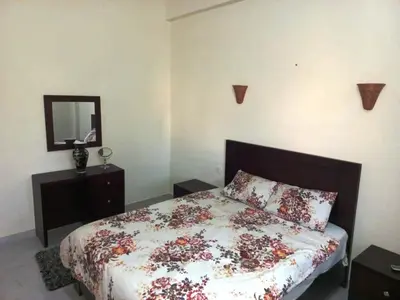 a bedroom with a bed with a dresser and a mirror at Villa Victoria Old Nile View in Luxor