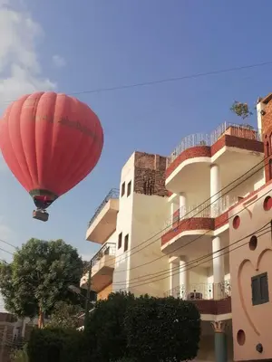 a red balloon flying in front of a building at Flower of Desert in Luxor