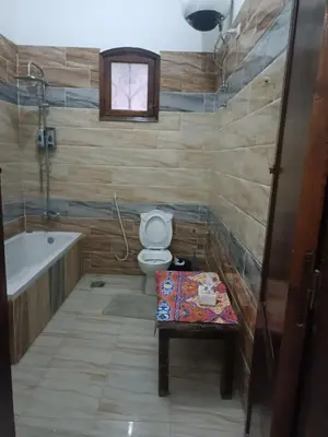 a bathroom with a toilet and a tub and a table at Flower of Desert in Luxor