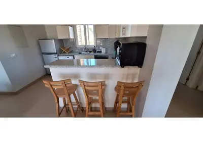 a kitchen with a bar with four chairs in it at El Gouna Waterside, 2-Bd Ground Floor Sleeps 4 Persons in El Gouna
