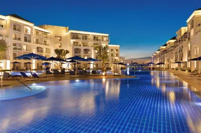 a swimming pool at a resort at night at Pickalbatros Blu Spa Resort - Adults Friendly 16 Years Plus- Ultra All-Inclusive in Hurghada