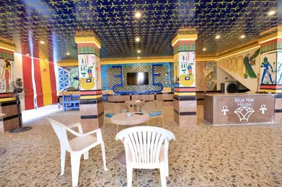 a room with two chairs and a tv in it at Blue Nile House in Luxor