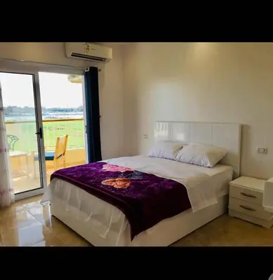 a bedroom with a large bed and a balcony at Blue Nile House in Luxor