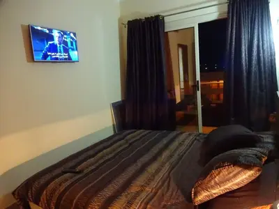 a bedroom with a bed with a tv on the wall at Florenza - sea view in Hurghada