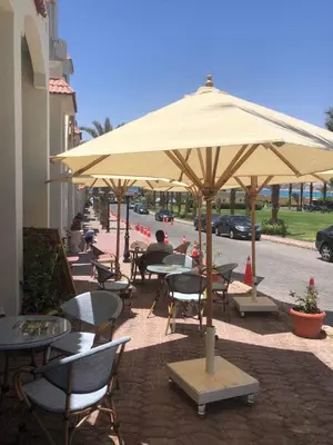 a group of tables and chairs under an umbrella at Apartman Andalusie in Hurghada