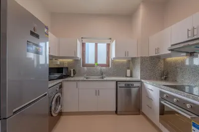 a kitchen with white cabinets and a sink and a dishwasher at Fresh Breeze High-End 2BR Villa with Private Pool, Sabina, El Gouna in Hurghada