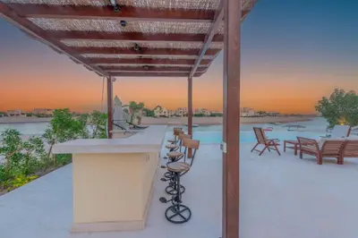 a patio with a bar and a table and chairs at Fresh Breeze High-End 2BR Villa with Private Pool, Sabina, El Gouna in Hurghada