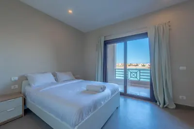 a bedroom with a large bed and a large window at 3BR Family Villa in Sabina, El Gouna. Lagoon & Private Pool in Hurghada