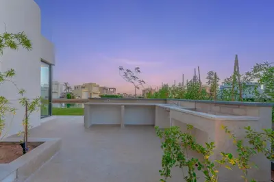 an outdoor area of a building with a table and plants at Light-Filled 4-Bedroom Villa in Tawila, El Gouna. Jacuzzi & Lagoon in Hurghada