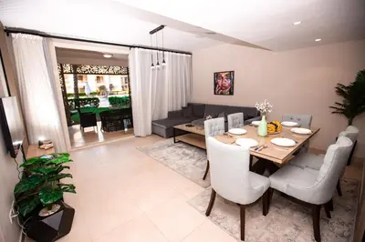 a dining room and living room with a table and chairs at Luxurious Sea view 2 BR & private Garden to the pool at Mangroovy in Hurghada