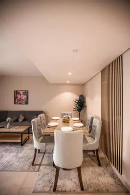 a dining room with a table and chairs and a couch at Luxurious Sea view 2 BR & private Garden to the pool at Mangroovy in Hurghada