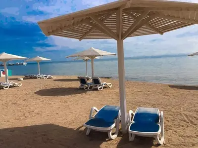 a group of chairs and umbrellas on a beach at Selena Bay Resort luxury 1 bedroom Apartments in Hurghada
