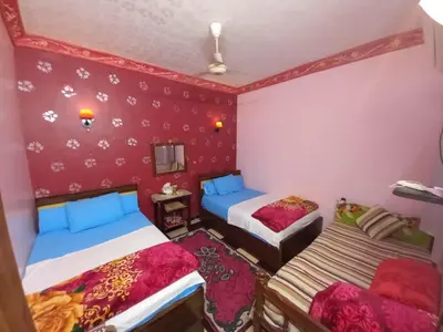two beds in a room with pink walls at Sabrina home in Aswan