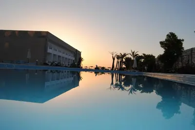 an empty swimming pool with the sunset in the background at Cecelia resort in Hurghada