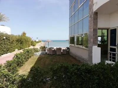 a building with a yard next to the beach at Cecelia resort in Hurghada