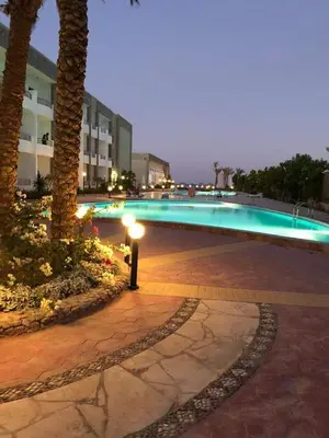 a swimming pool with a light next to a building at Cecelia resort in Hurghada
