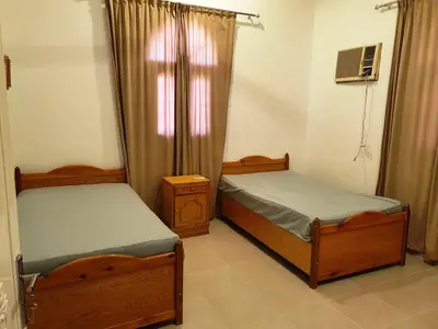 a bedroom with two beds and a window at Family House in Luxor