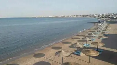 a row of umbrellas on a beach with the ocean at منتجع سيسيليا cecelia resort in Hurghada