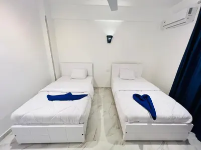 two beds in a room with blue pillows on them at Happiness Guest House in Luxor