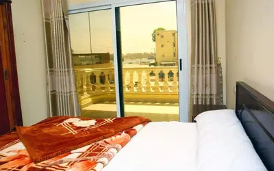 a bedroom with a bed and a large window at Egypt sun accommodation Spiritualities in Luxor