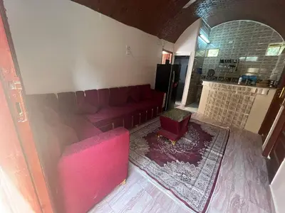 a living room with a red couch and a chair at Hamd Nubian Guest House in Aswan