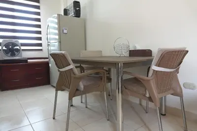 a dining room table with chairs and a refrigerator at Private 1 bedroom flat with garden in Makadi in Hurghada