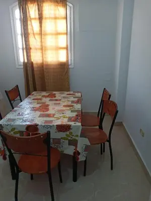 a dining room with a table and chairs and a window at new ikea flat 1 in Hurghada