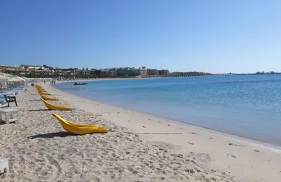 a row of yellow umbrellas on a beach at Tawaya sahl hashesh in Hurghada