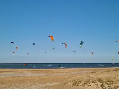 a group of people flying kites on a beach at Mangarovy El Gouna in Hurghada
